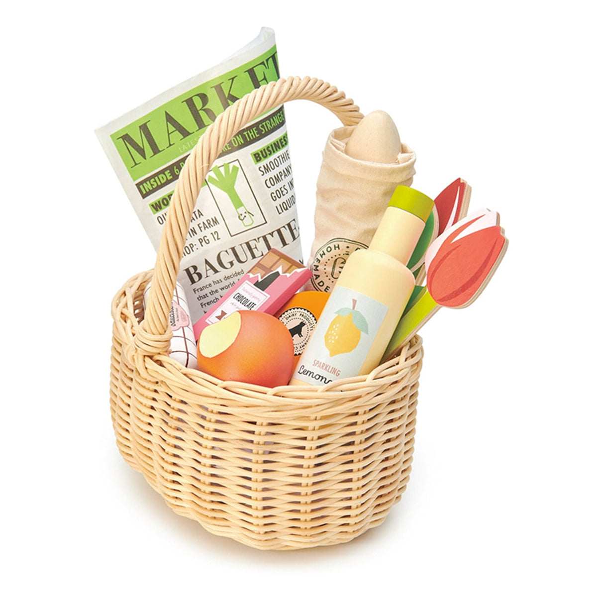 Toy wicker basket with groceries including a baguette, apples, and a bottle on a white background