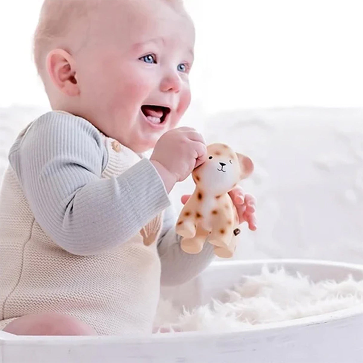 Baby holding a leopard-patterned baby rubber toy