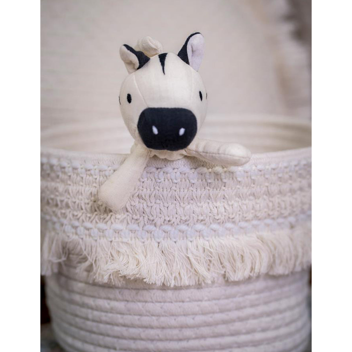 Zebra toy in a white cloth basket