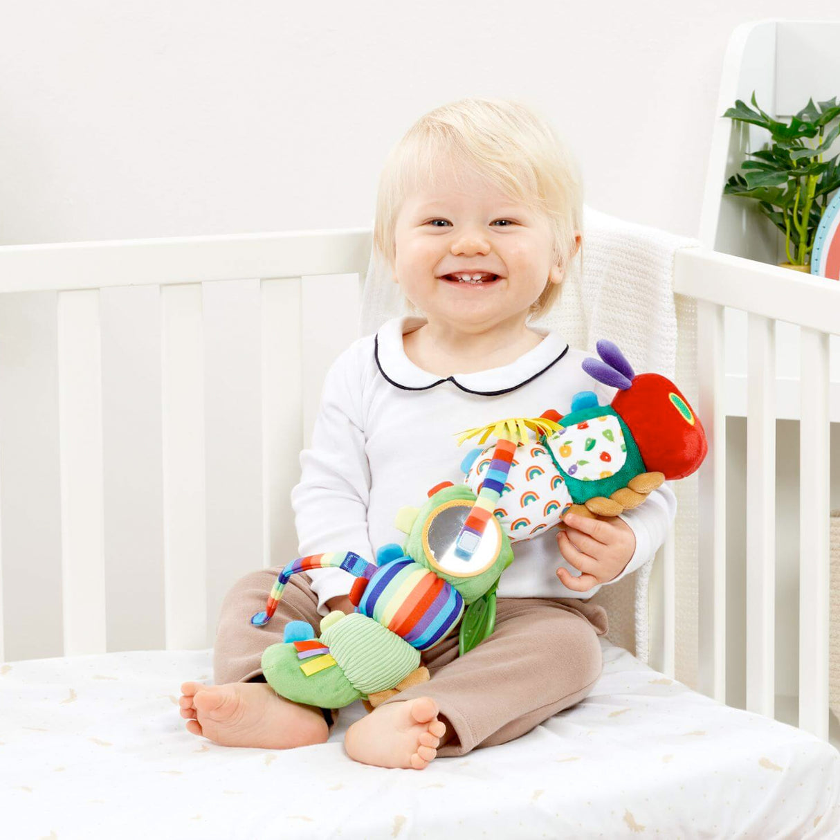 Baby playing with Colorful Very Hungry caterpillar shaped baby toy with various textures and mirrors