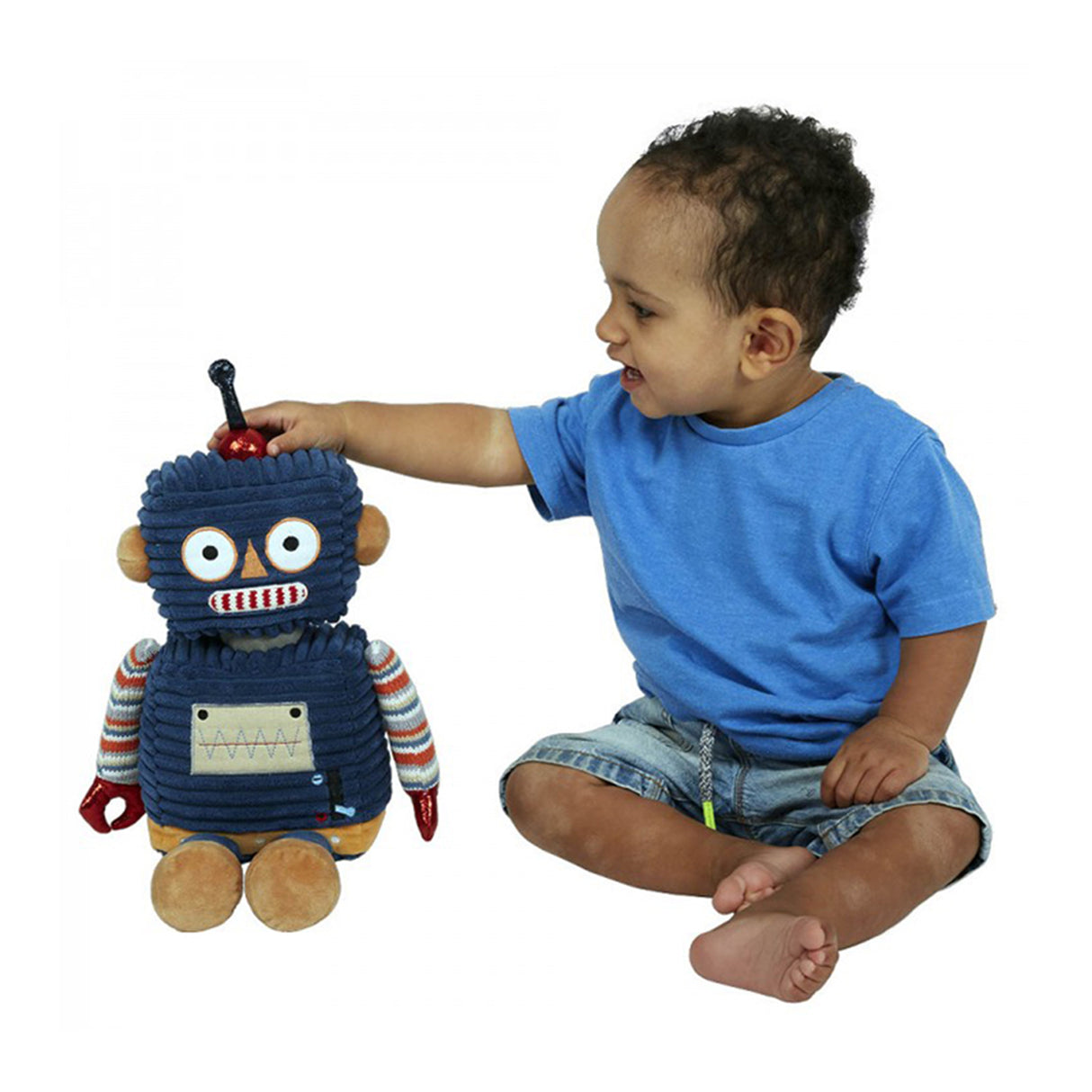 Baby playing with a dark blue robot toy with a striped shirt and brown feet, made of soft textiles.