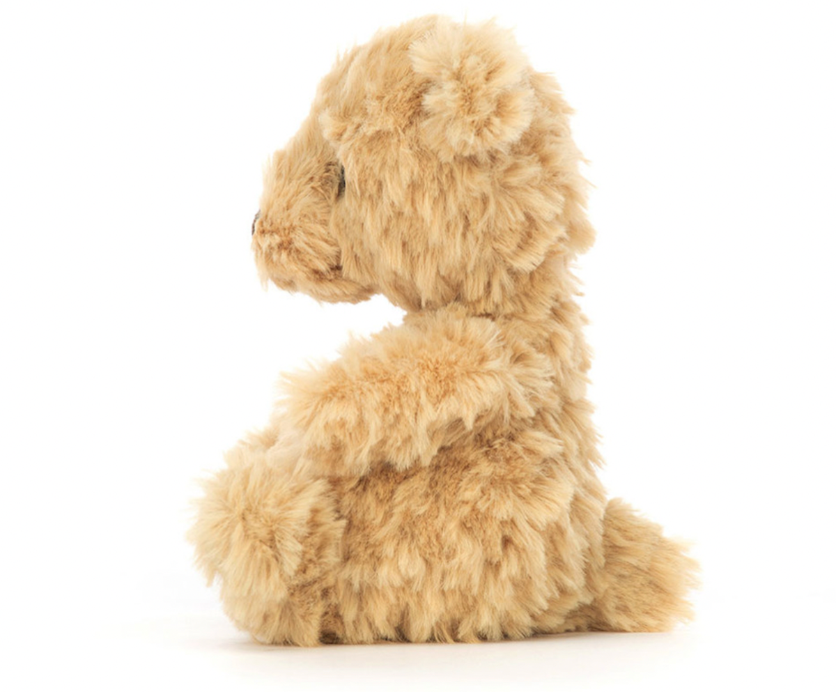 A small, plush, brown teddy bear with a tuft of honey-colored fur,