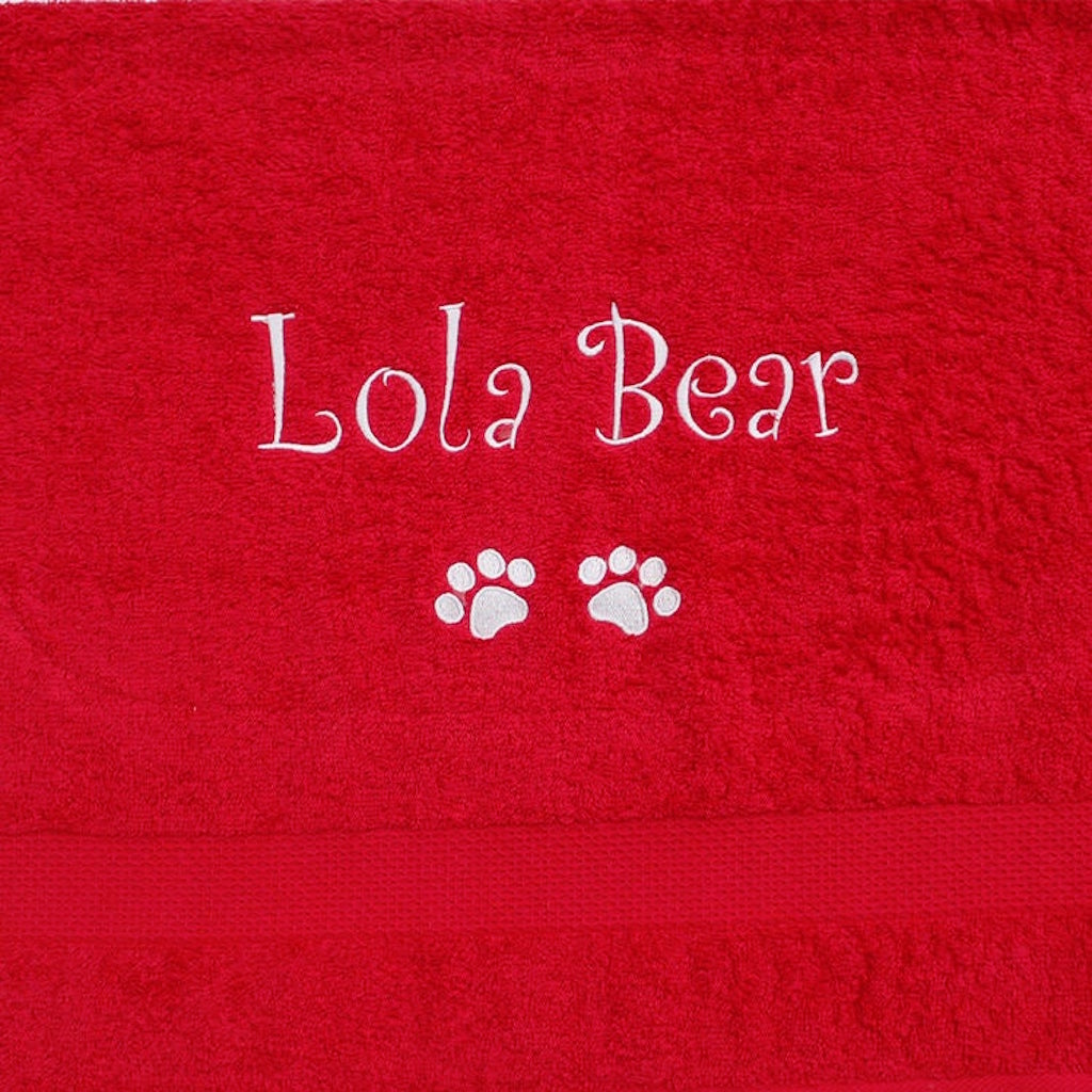 A large red personalised Dog Towel with name and dog paws