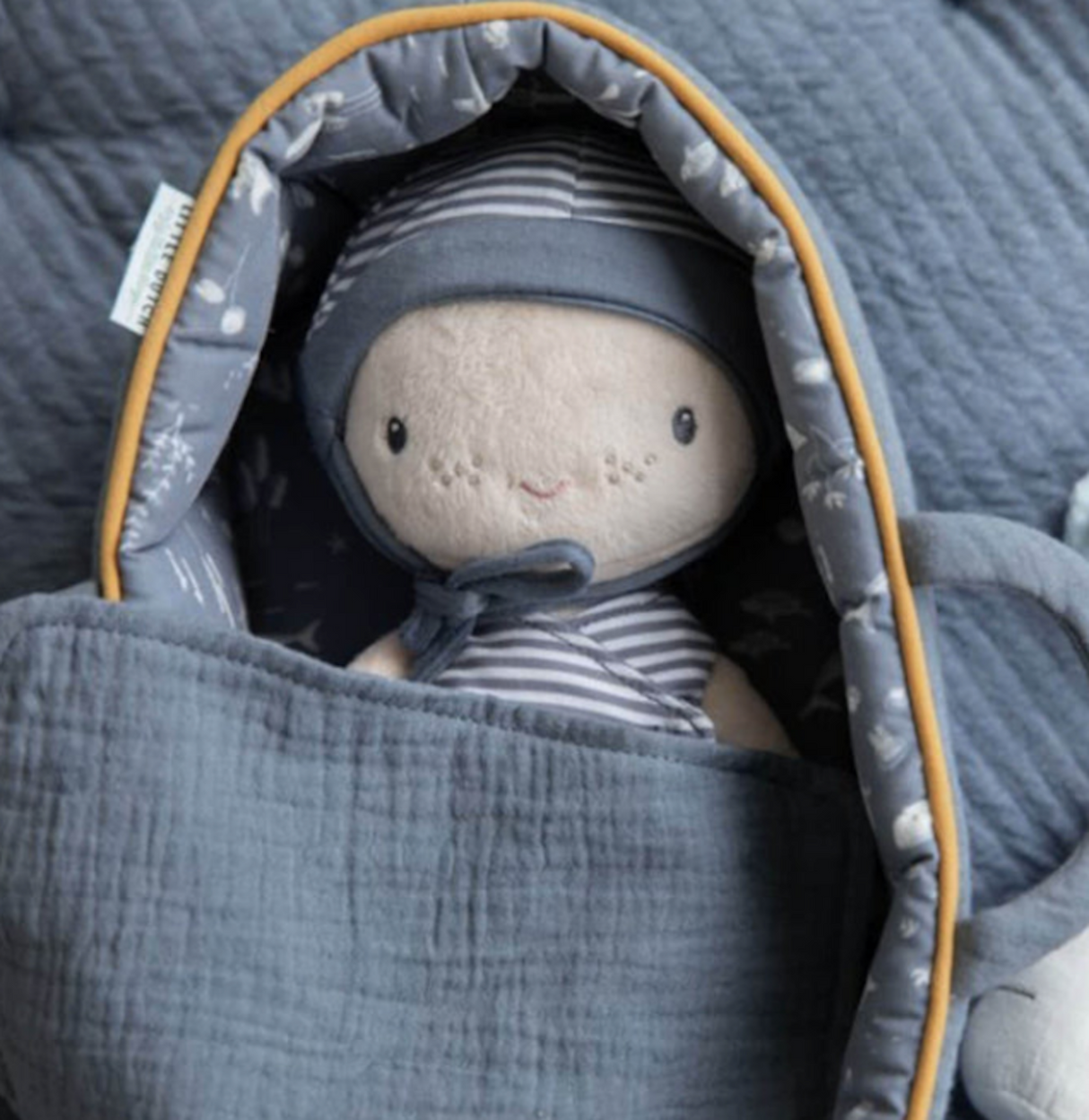 Soft toy baby doll wrapped in a gray blanket with a striped outfit