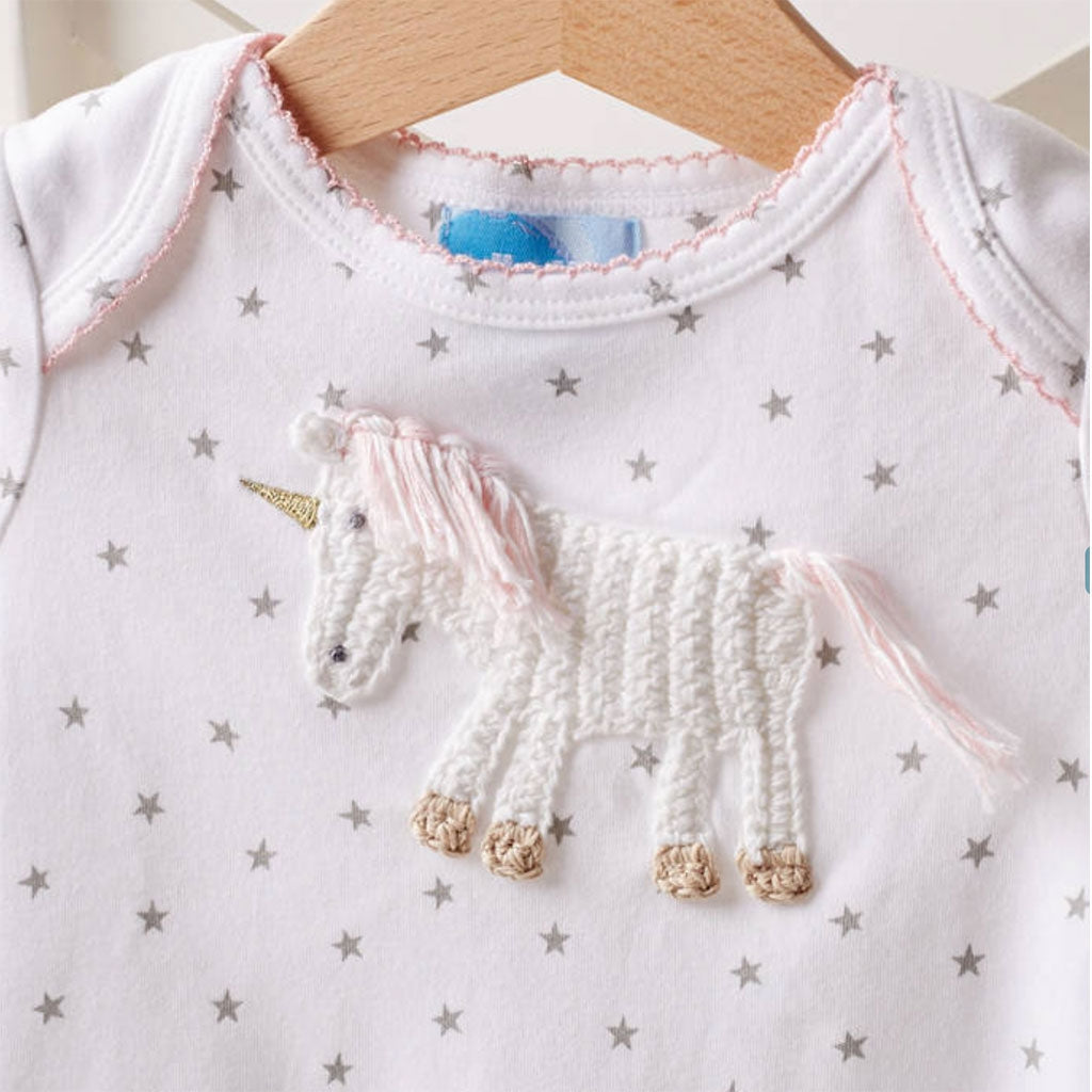 Close up of a Albetta babygrow with a beautiful hand crocheted unicorn - would make the perfect baby gift for a little girl.