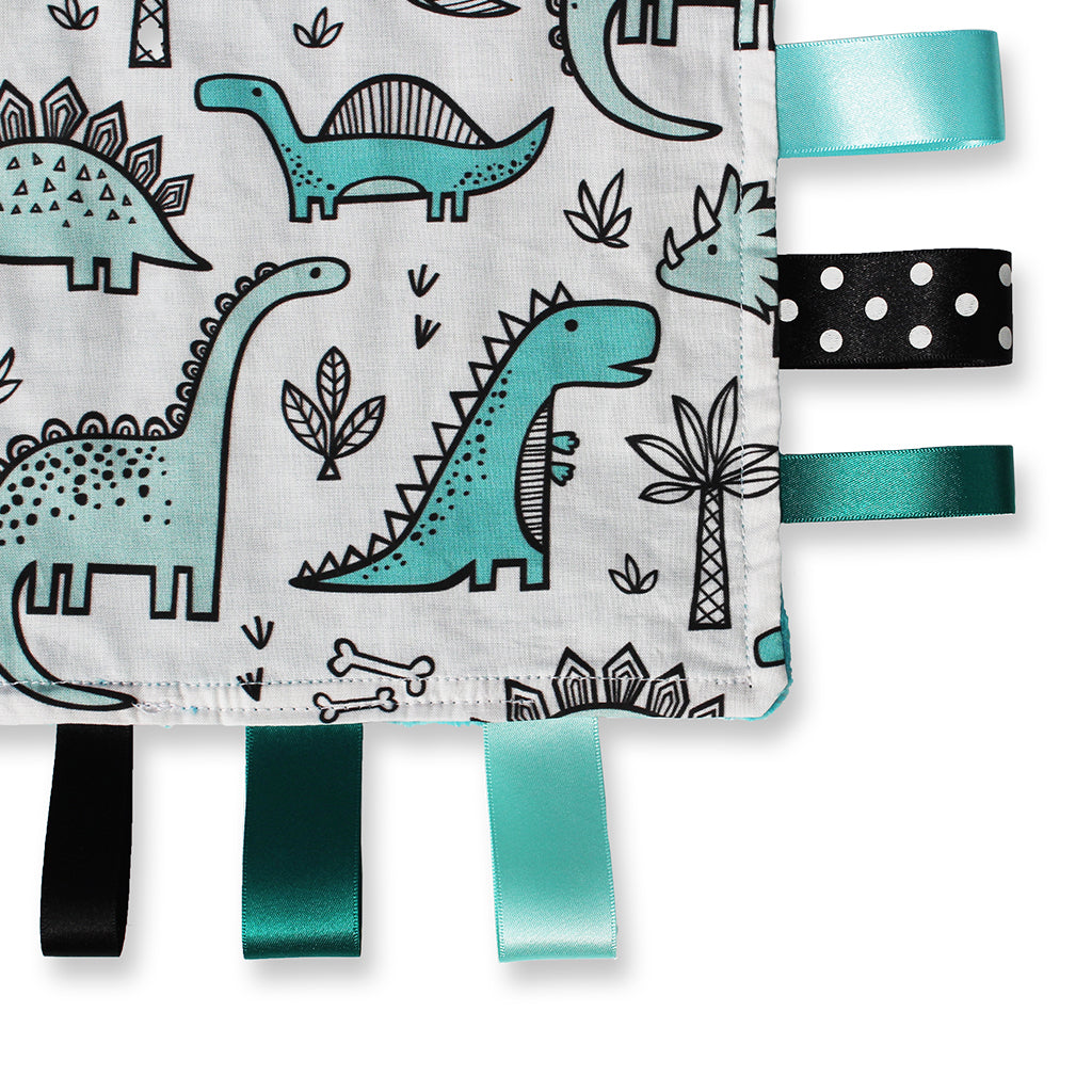 Close up view of a lovely unique handmade Baby Taggy comforter which can be personalised. Professionally made using 'Dinosaur' fabric