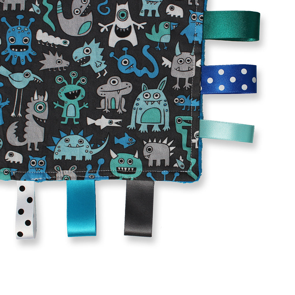 Close up view of a lovely unique handmade Baby Taggy comforter Professionally made using adorable 'Monsters' fabric