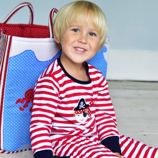A young lad with a red and white striped pirate pyjamas suit by Powell Craft