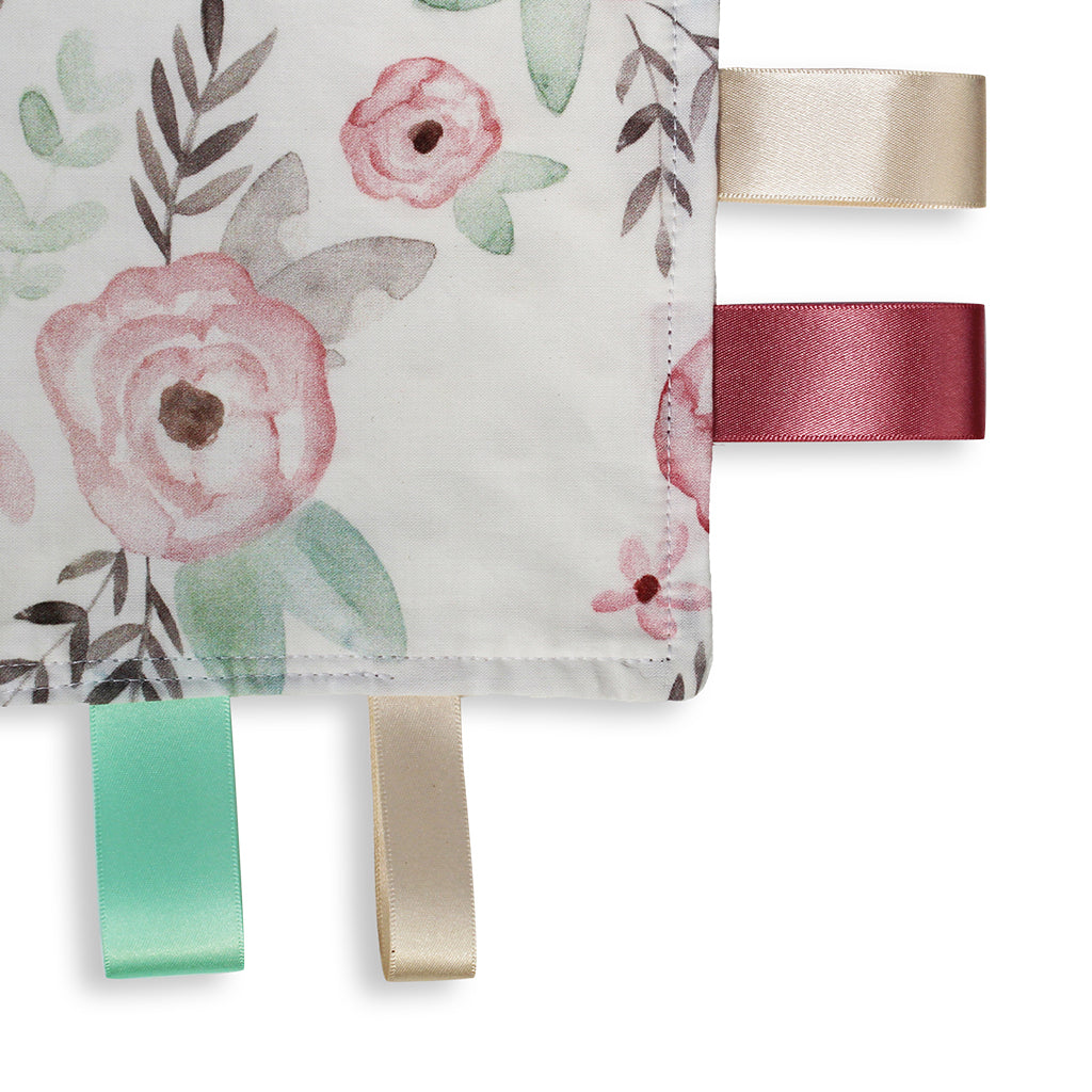 Close up view of a lovely unique eco friendly handmade Baby Taggy comforter Professionally made using 'Wild Rose' fabric