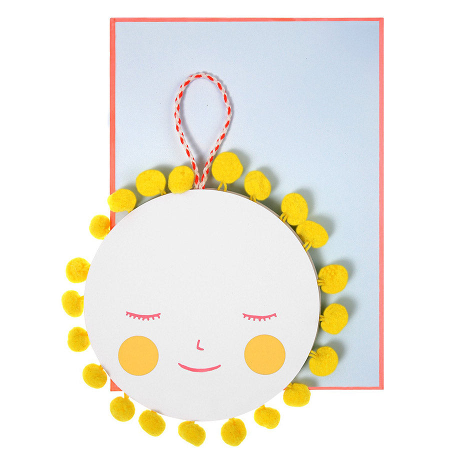 Meri Meri new baby card with cut-out sun design embellished with lots of bright orange pom-poms