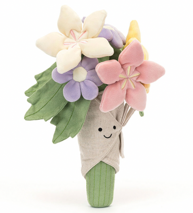 A plush toy bouquet of flowers with varied colors like pink, purple, and yellow, with a smiling face on the front and wrapped in a beige cloth.