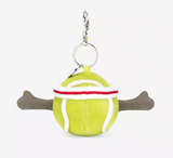 A plush toy in the shape of a yellow tennis ball with red and white details, wearing a white and red headband, attached to a silver clip and chain.