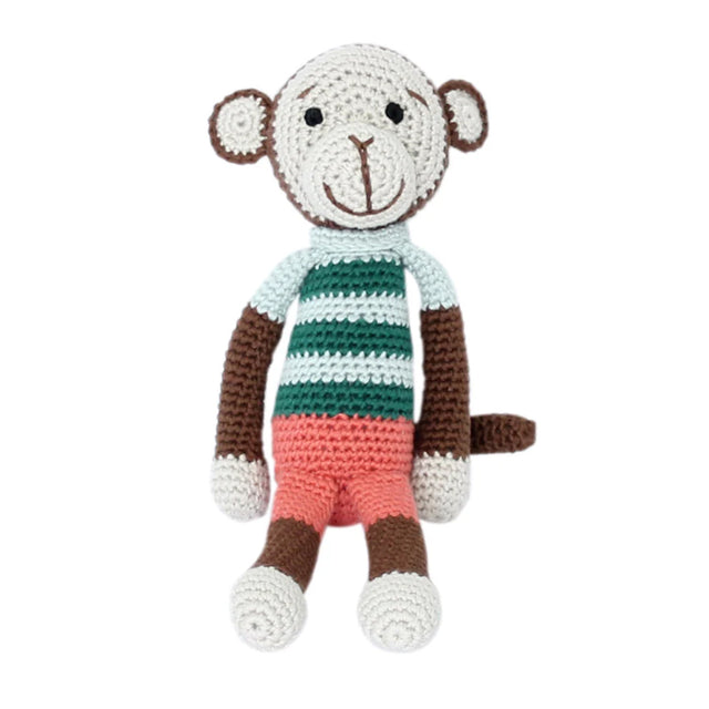 Organic crochet boy monkey soft toy in green striped top and pink shorts, handmade from bamboo and cotton yarn, on a white background