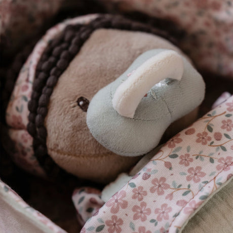 Close up of Little Dutch Baby Doll Evi face with magnetic dummy attached, nestled in floral-lined basket