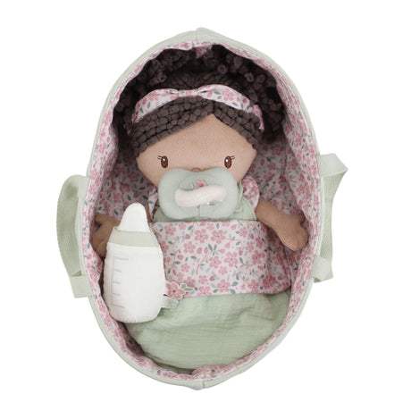 Little Dutch Baby Doll Evi lying in sage green travel basket holding a bottle