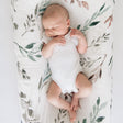 Newborn baby sleeping on a botanical patterned blanket