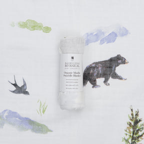Organic muslin swaddle blanket with nature-themed design on a white background