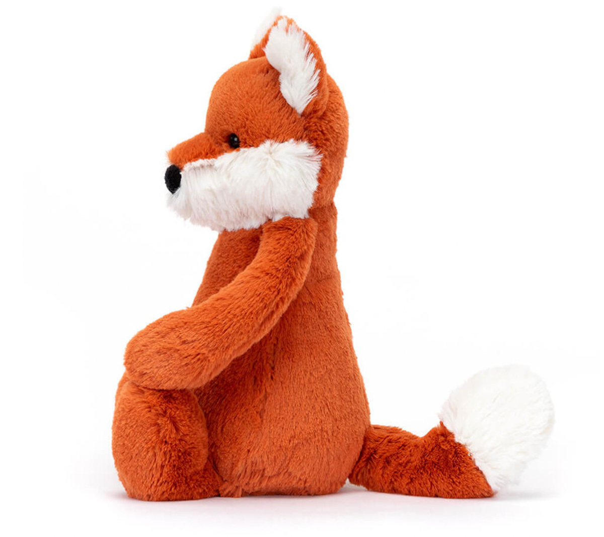A plush toy depicting a fox cub with fluffy white ears, feet, and tail-tip, sitting with a reddish-brown body.