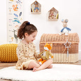 Child playing with a Beatrix Potter Mr Todd plush fox toy with a green outfit in a room with a wicker basket and growth chart.