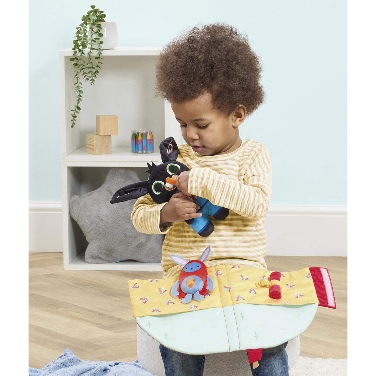 A young child holding a Bing bedtime house set
