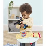 A young child holding a Bing bedtime house set