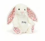 white Soft bunny toy with pink cherry blossom fabric patterned ears and feet wearing a personalised knitted jumper