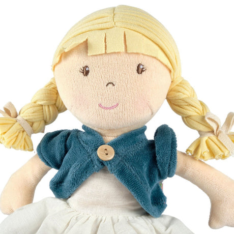 Soft rag doll with blonde hair, blue cardigan with wooden button, and white dress on a white background