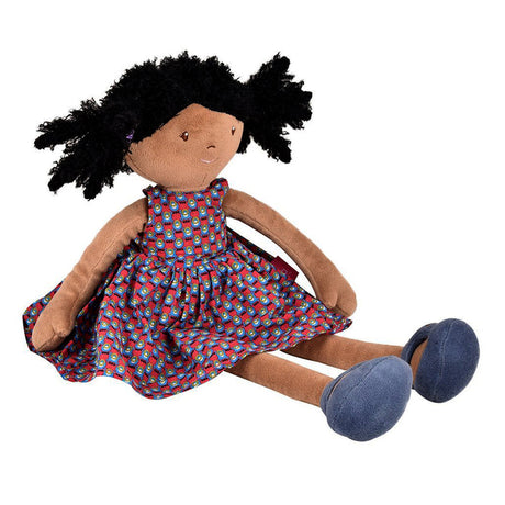 Stuffed rag doll with black hair, red and blue patterned dress, and blue shoes on a white background