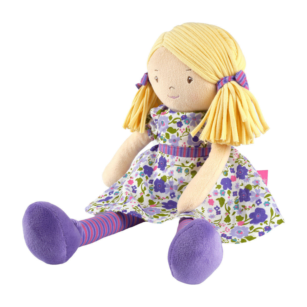 Soft rag doll with blonde hair, purple and green floral dress, and striped leggings on a white background