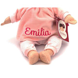Plush doll in pink outfit with 'Emilia' embroidered on it, on a white background