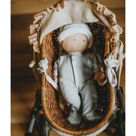 Baby doll in a wicker crib with a soft, blurred background