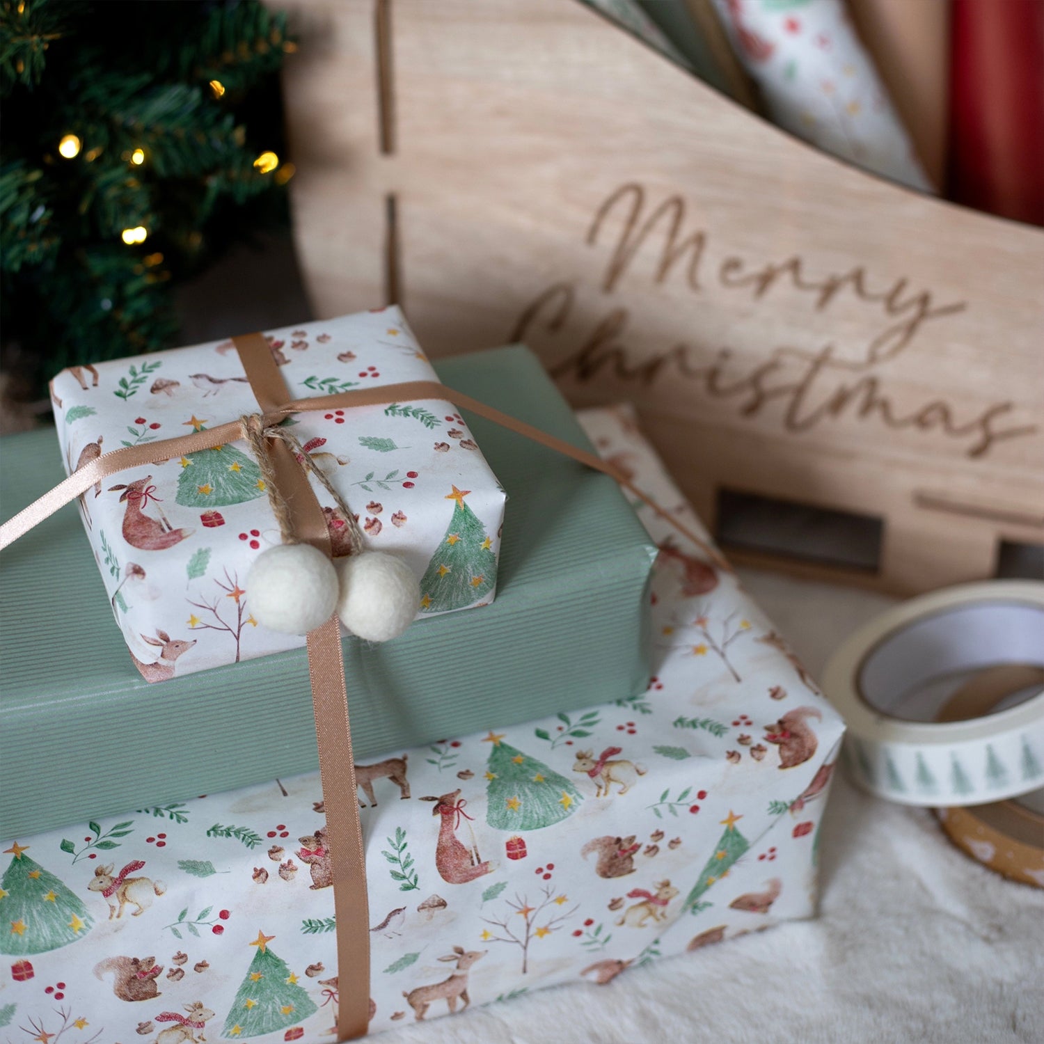 Gift boxes wrapped in festive paper with a 'Merry Christmas' sign in the background.