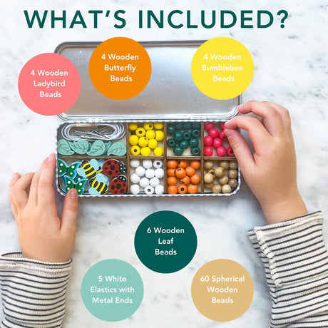Children's hands opening a container of wooden beads with product details on a marble surface.