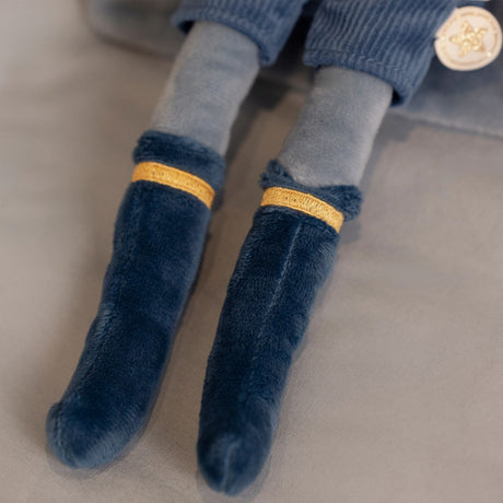 Close-up of blue socks with gold bands on a neutral background