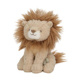 A soft lion toy with a fluffy tan and cream body, a golden-brown mane, and a small green tag on its side, photographed against a plain white background.
