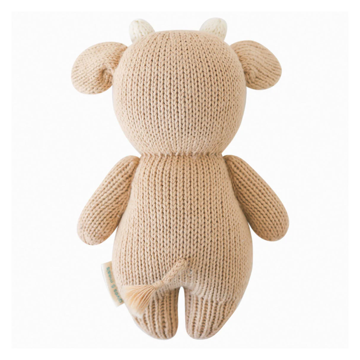 Knitted cow toy with ears and horns on a white background