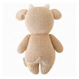 Knitted cow toy with ears and horns on a white background