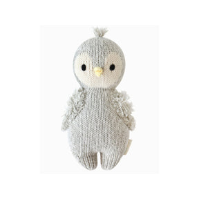 Handknitted baby penguin soft toy on a white background