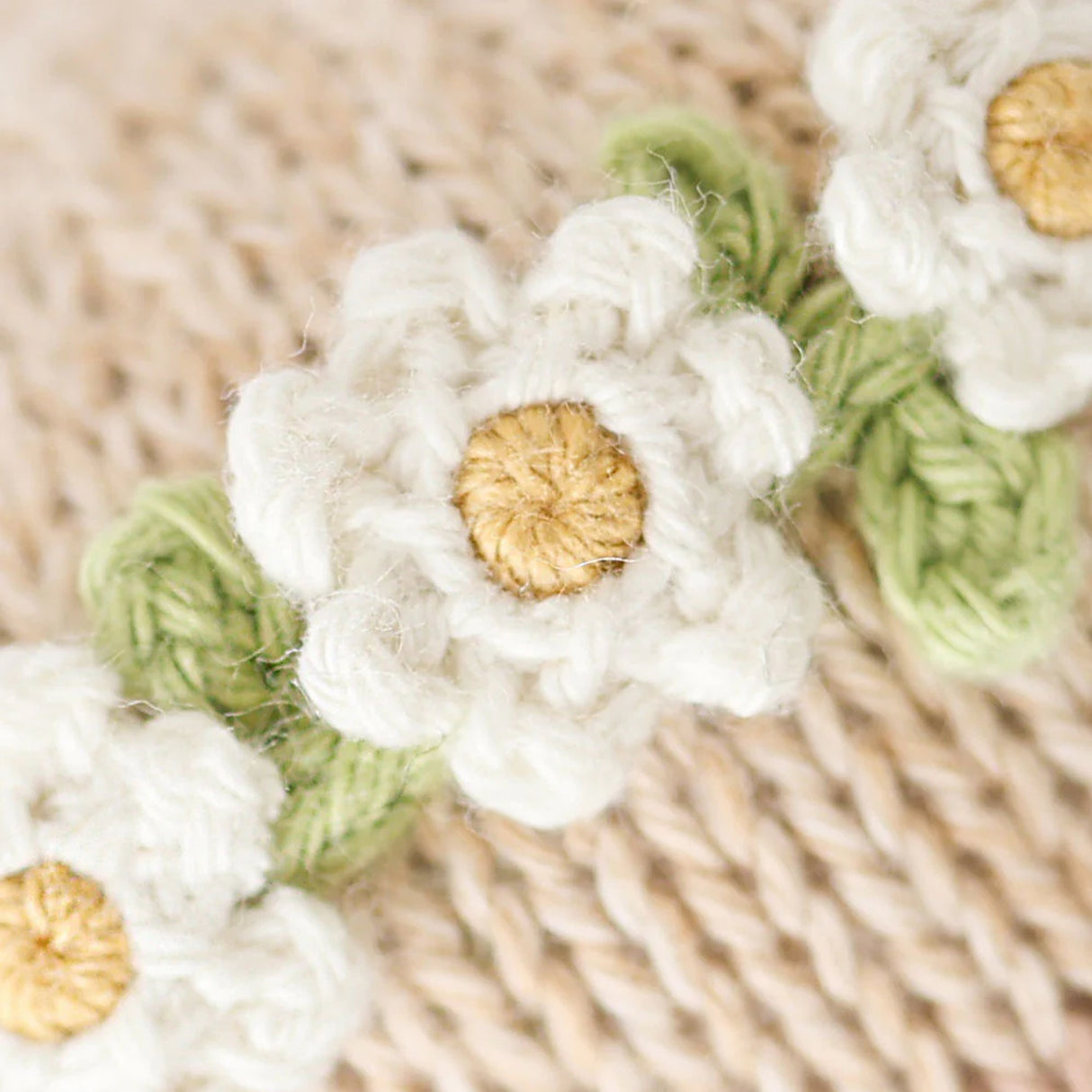 Close-up of white crocheted flowers with gold centers 
