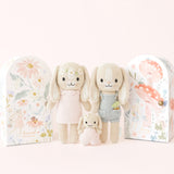 Knitted dolls with floral packaging on a white background