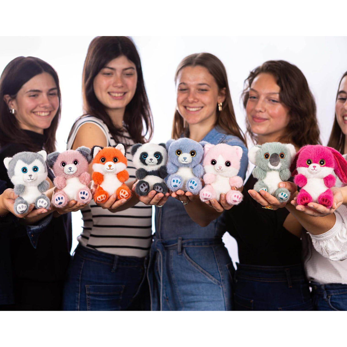 Full Cutydoos collection of small plush animal soft toys by Rainbow Designs held by four young women, including husky, pink dog, fox, panda, koala and rabbit