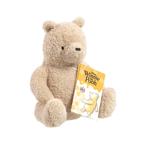Disney Winnie the Pooh 100 curly plush bear sitting with Rainbow Designs gift tag, side angle on white background