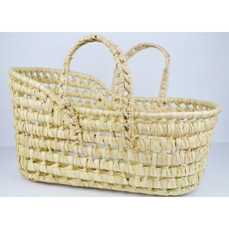 A beige wicker  woven bassinet or moses basket with two side handles, suitable for carrying dolls or soft toys.