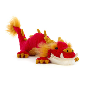 Red and yellow plush dragon toy on a white background