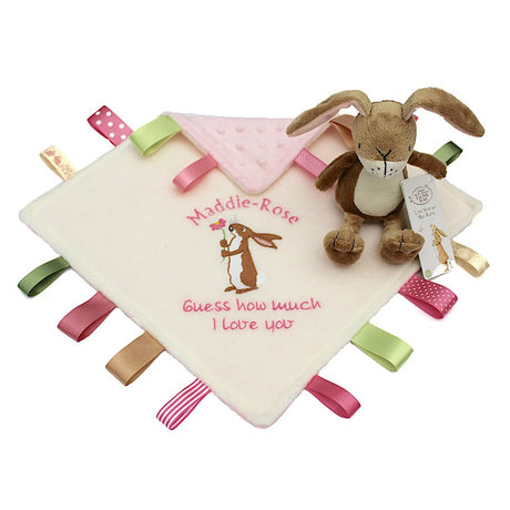 Baby comfort blanket with embroidered text and a plush rabbit rattle toy on a white background