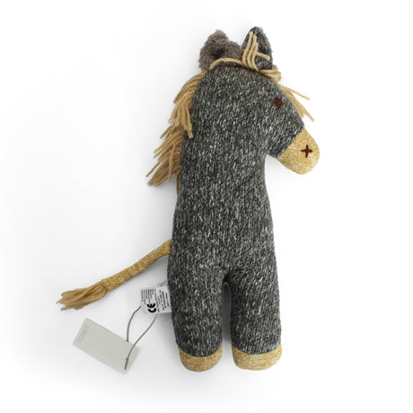 A handmade woolly horse plush toy in dark gray and beige heathered yarn, featuring a tan fringed mane and tail.