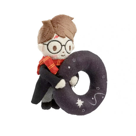 Stuffed toy resembling a character with glasses and a scarf, holding a large ring with star patterns on a white background.