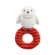A plush Harry Potter Hedwig baby ring rattle rattle with a white owl on top sitting on a red and orange striped ring.