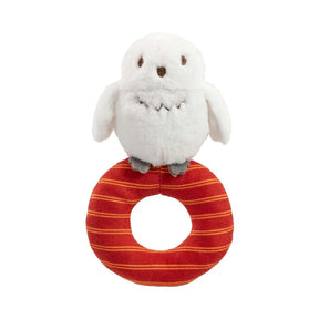 A plush Harry Potter Hedwig baby ring rattle rattle with a white owl on top sitting on a red and orange striped ring.