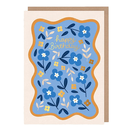 Hopscotch Paper Co. blue floral Happy Birthday card with gold foil text and wavy orange border, with kraft envelope on white background